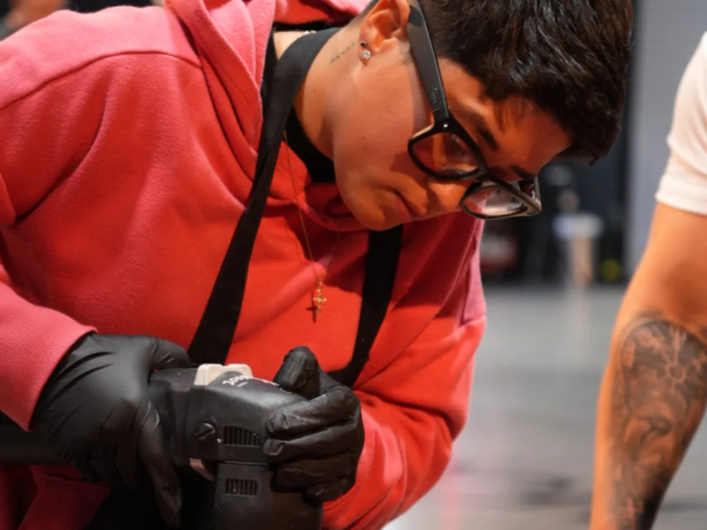 Auto Detailing Pro detailer running a dual-action polisher over a red car bonnet during paint correction